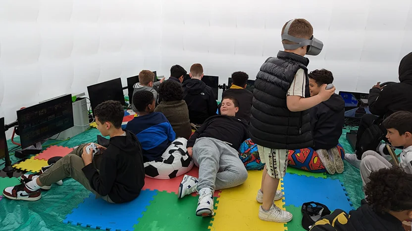 12 kids playing video games in a tent